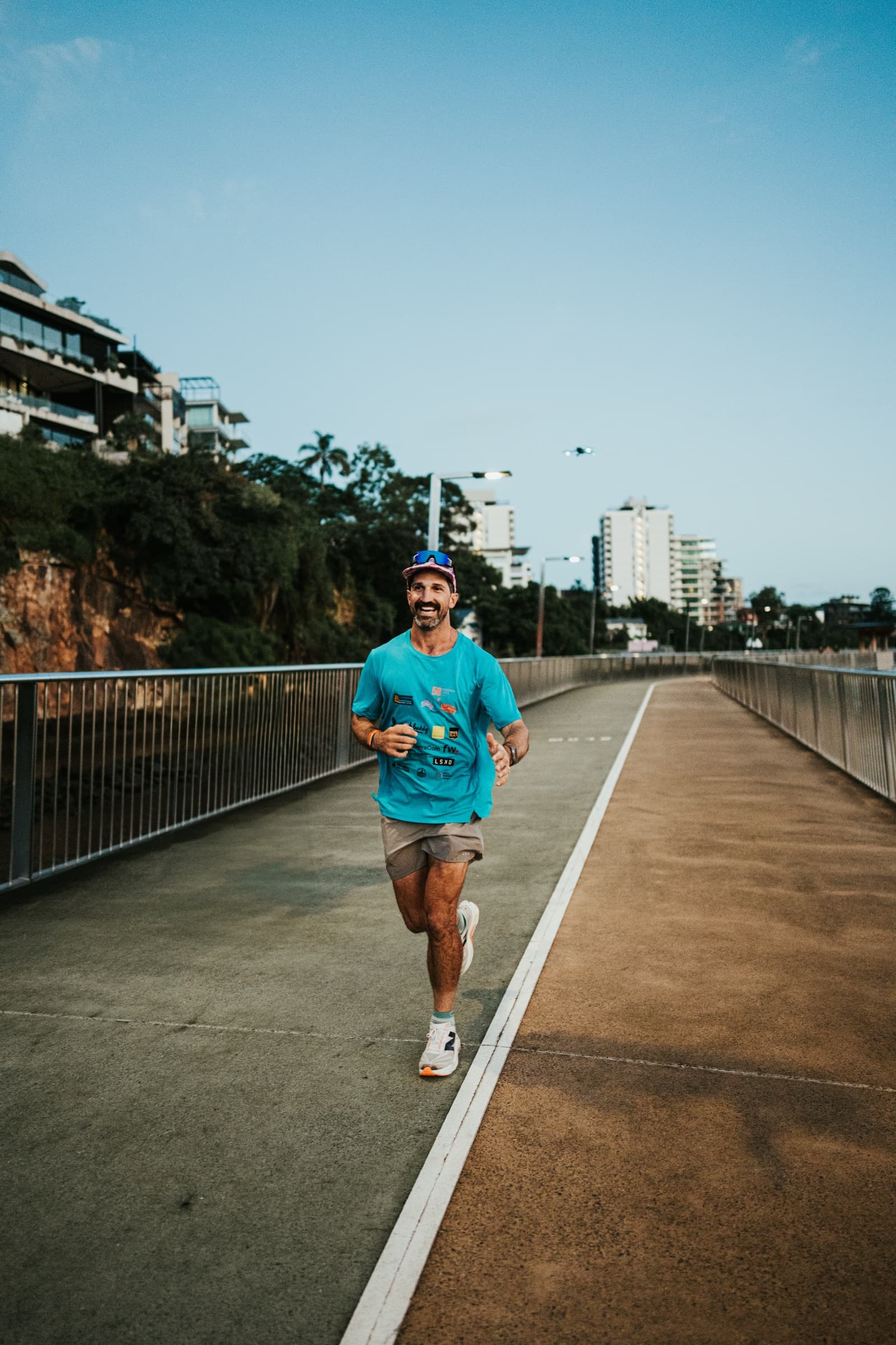 Lachlan Stuart running on an open road toward sunrise mountains.